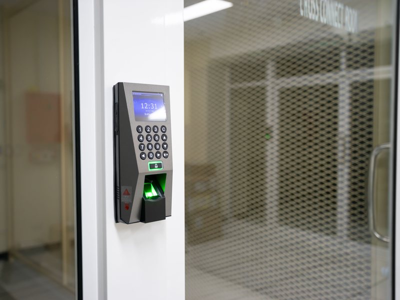 Reloj biométrico instalado junto a la puerta de un taller